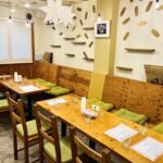 FRIENDS for Gの会場。木のテーブルと緑の座席、星形の照明